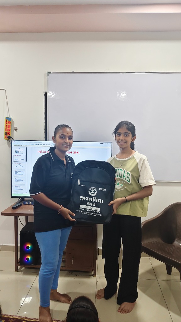 Academy mentors presenting school bags to female students